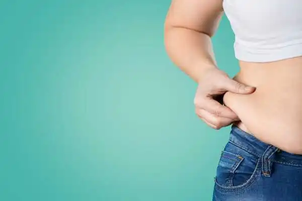 Image of woman pinching her love handles to show weight gain Maldon